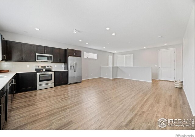 4672 Clear Creek Dr, Longmont, CO 80504 - kitchen featuring appliances with stainless steel finishes, light countertops, recessed lighting, light wood-style floors, and baseboards