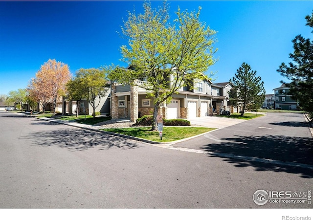 5775 29th St Unit 101, Greeley, CO 80634 - view of front of house featuring a residential view, an attached garage, concrete driveway, and brick siding