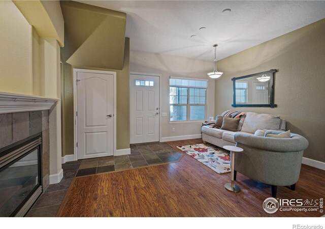 5775 29th St Unit 101, Greeley, CO 80634 - living room with baseboards, stone finish flooring, and a tiled fireplace