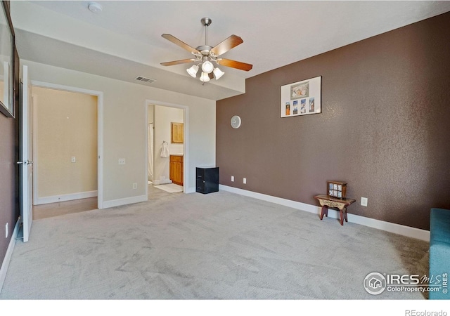 5775 29th St Unit 101, Greeley, CO 80634 - unfurnished bedroom with baseboards, light carpet, ensuite bath, and visible vents