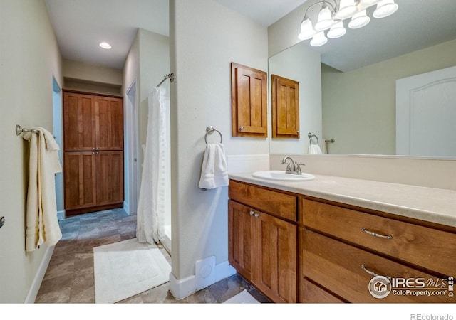 5775 29th St Unit 101, Greeley, CO 80634 - full bathroom with baseboards, curtained shower, a chandelier, and vanity