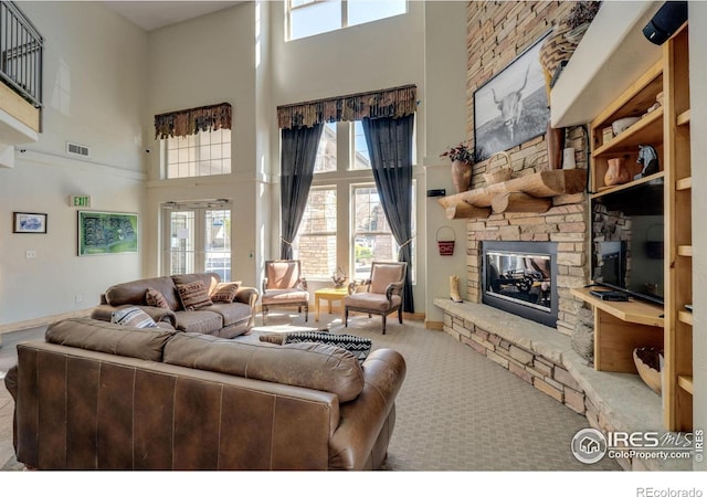 5775 29th St Unit 101, Greeley, CO 80634 - living area featuring visible vents, carpet, a high ceiling, and a fireplace