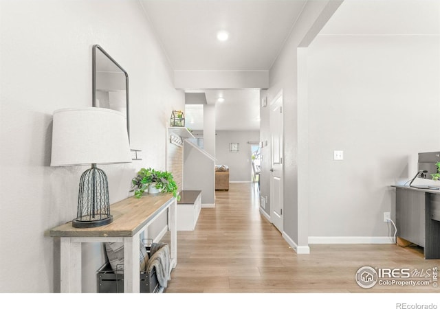 corridor with baseboards and light wood-style flooring