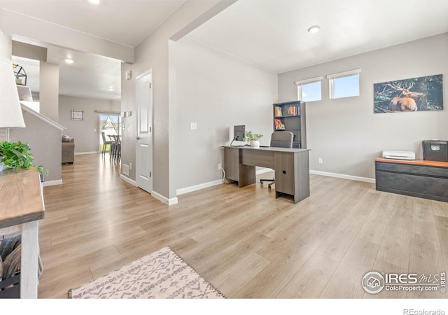 office space featuring recessed lighting, baseboards, and light wood-type flooring