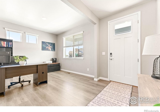 foyer featuring baseboards and wood finished floors