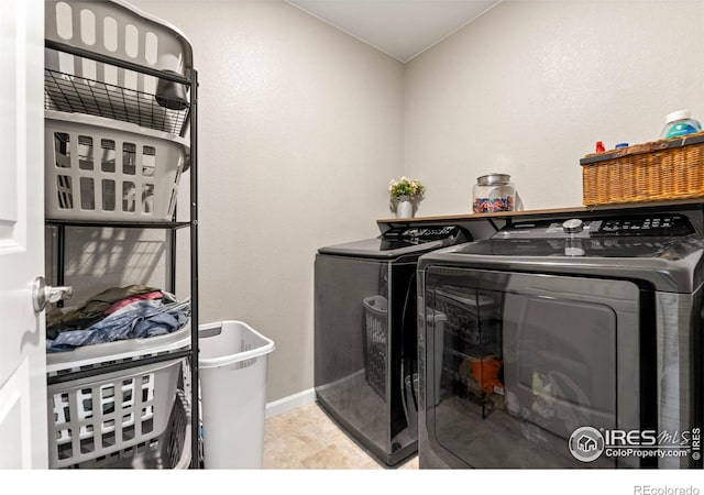laundry room with laundry area, washing machine and dryer, and baseboards