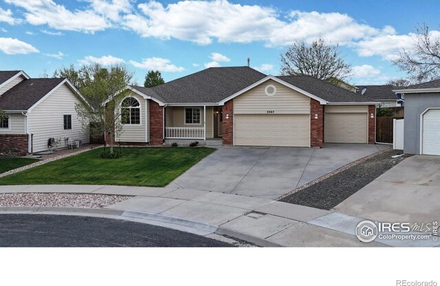 ranch-style home with a porch, driveway, a front yard, a garage, and brick siding