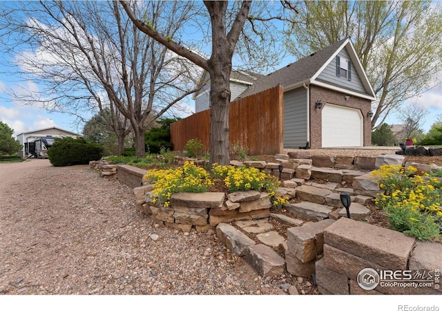view of side of home featuring fence and brick siding