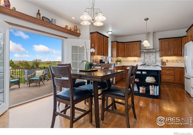 dining room featuring a chandelier, wood finished floors, and a healthy amount of sunlight