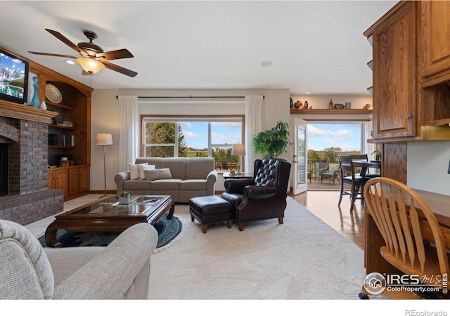 living area featuring a ceiling fan, a fireplace, recessed lighting, and built in shelves