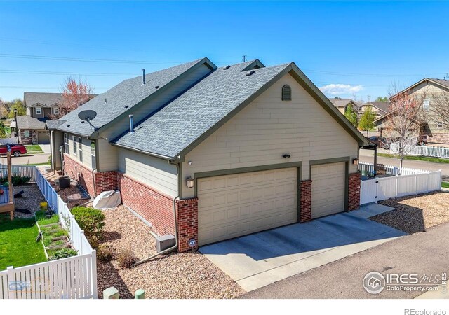 view of front of house featuring a garage, brick siding, fence, concrete driveway, and a shingled roof