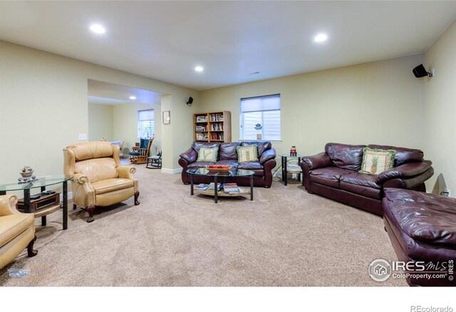 carpeted living area featuring recessed lighting, baseboards, and plenty of natural light