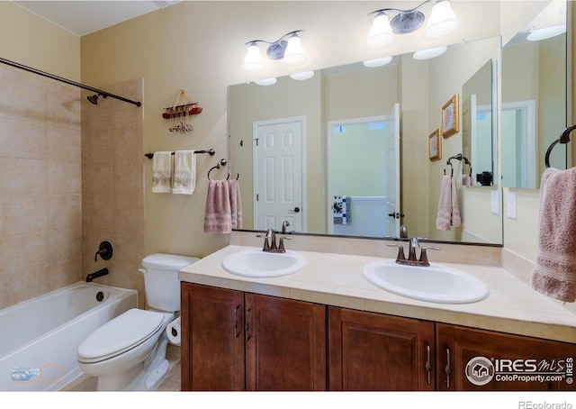 full bath featuring double vanity, a sink, shower / tub combination, and toilet