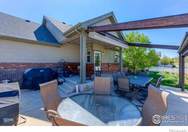 view of patio / terrace featuring fence, outdoor dining area, and a grill
