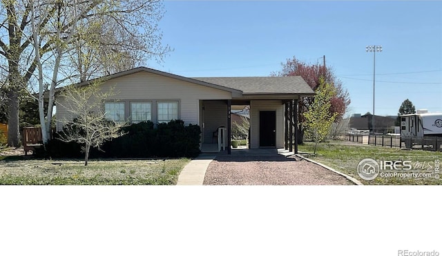 910 H Ave, Limon, CO 80828 - view of front facade with fence, an attached carport, and aphalt driveway