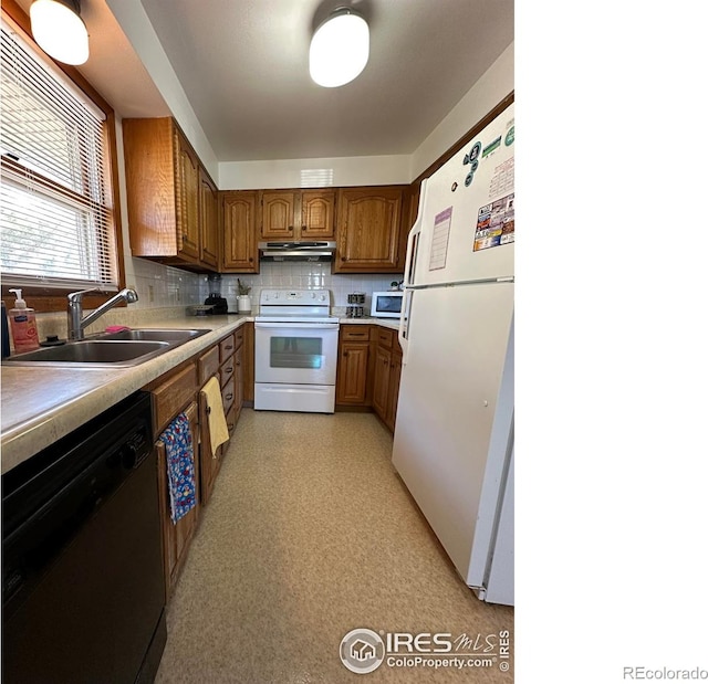 910 H Ave, Limon, CO 80828 - kitchen with brown cabinetry, decorative backsplash, white appliances, under cabinet range hood, and a sink
