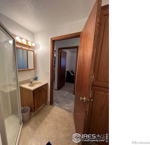 910 H Ave, Limon, CO 80828 - full bathroom with vanity, a textured ceiling, and a shower stall