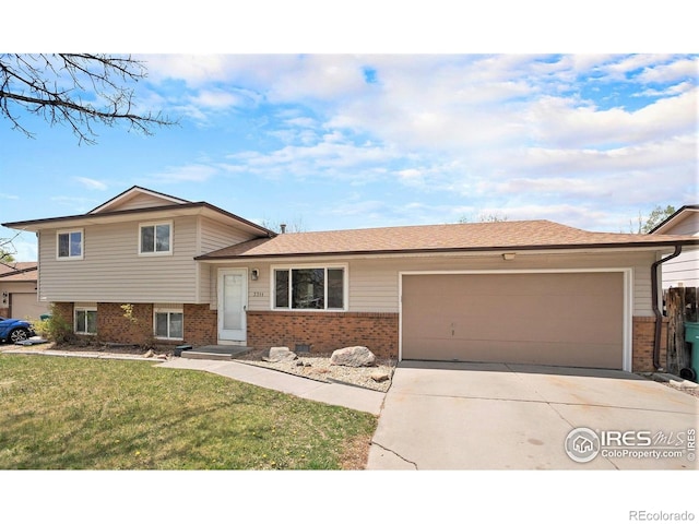 split level home with concrete driveway, brick siding, an attached garage, and a front lawn