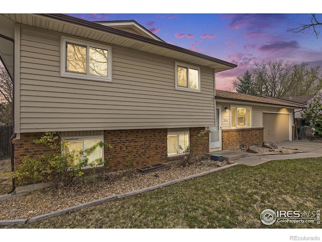 view of front facade with brick siding, driveway, and a garage