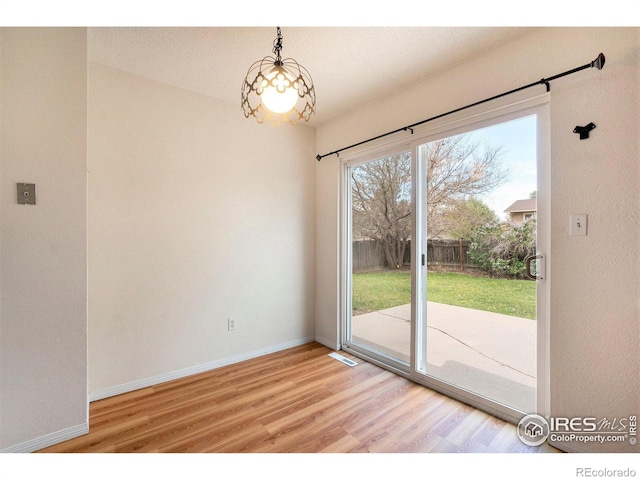 unfurnished dining area featuring light wood-style floors, baseboards, and visible vents