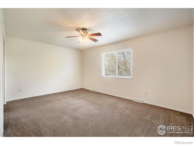carpeted empty room with visible vents, a ceiling fan, and baseboards