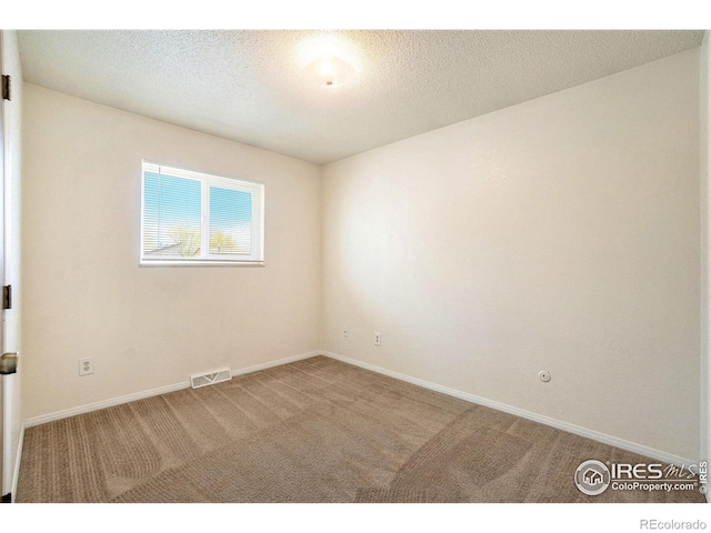 carpeted spare room with baseboards and visible vents
