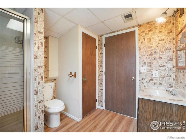 bathroom featuring vanity, toilet, a paneled ceiling, wood finished floors, and visible vents