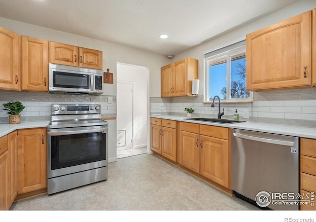 113 Balsam St, Fort Morgan, CO 80701 - kitchen with tasteful backsplash, a sink, light countertops, stainless steel appliances, and light floors
