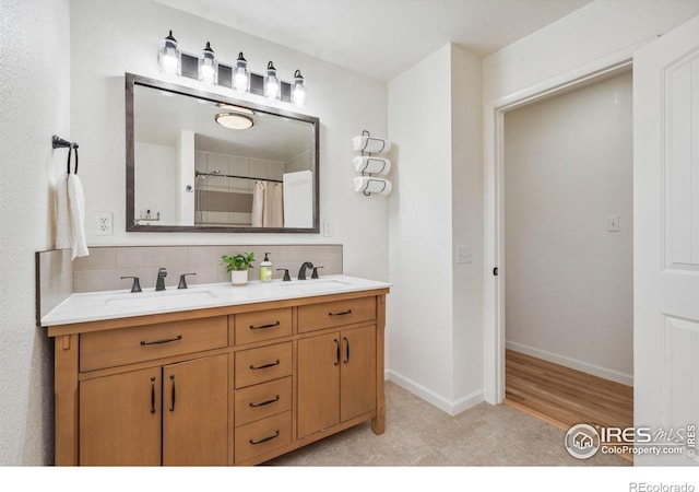 113 Balsam St, Fort Morgan, CO 80701 - bathroom with backsplash, double vanity, baseboards, and a sink
