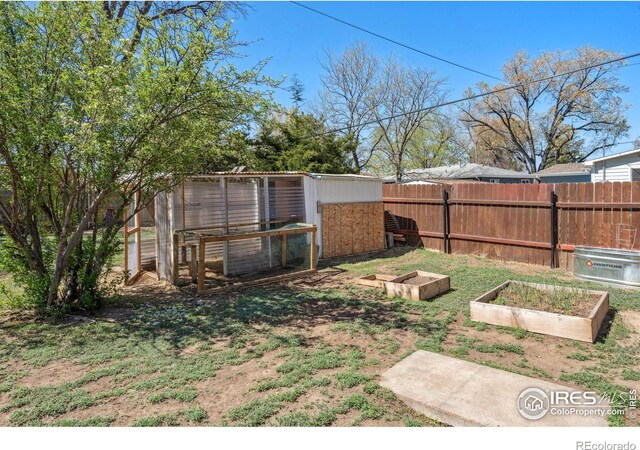 113 Balsam St, Fort Morgan, CO 80701 - view of yard with exterior structure, fence, an outbuilding, and a vegetable garden
