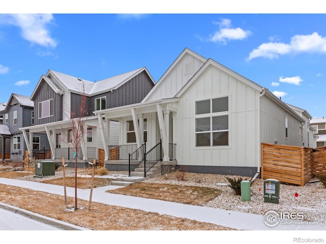modern farmhouse featuring central AC unit, board and batten siding, and a porch