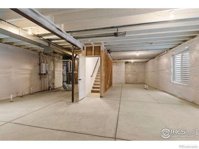 basement featuring stairs, heating unit, and water heater