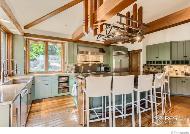 2307 Magnolia Dr, Nederland, CO 80466 - kitchen with a sink, tasteful backsplash, green cabinets, and stainless steel appliances