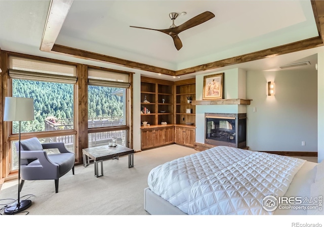 2307 Magnolia Dr, Nederland, CO 80466 - bedroom with visible vents, a raised ceiling, a multi sided fireplace, and carpet flooring
