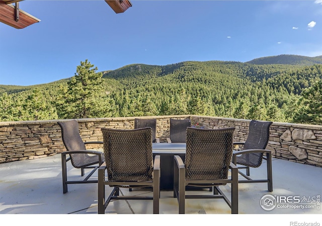 2307 Magnolia Dr, Nederland, CO 80466 - view of patio featuring a view of trees, outdoor dining area, and a mountain view