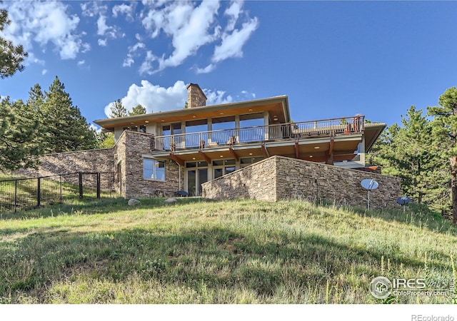 2307 Magnolia Dr, Nederland, CO 80466 - back of property with fence, a wooden deck, stone siding, and a chimney