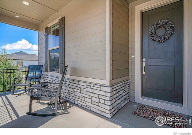 3295 Heron Lakes Pkwy, Berthoud, CO 80513 - property entrance featuring a porch and stone siding