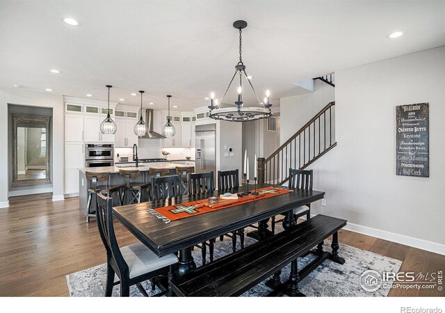 3295 Heron Lakes Pkwy, Berthoud, CO 80513 - dining room featuring baseboards, dark wood-type flooring, recessed lighting, and a chandelier