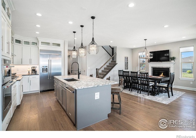 3295 Heron Lakes Pkwy, Berthoud, CO 80513 - kitchen with white cabinets, a sink, stainless steel appliances, recessed lighting, and dark wood-style floors