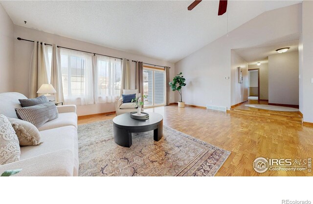 living area featuring visible vents, a ceiling fan, lofted ceiling, and wood finished floors