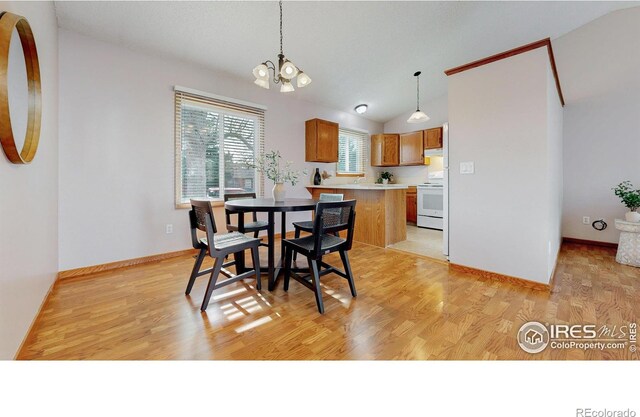 dining area featuring baseboards, light wood finished floors, lofted ceiling, and a notable chandelier