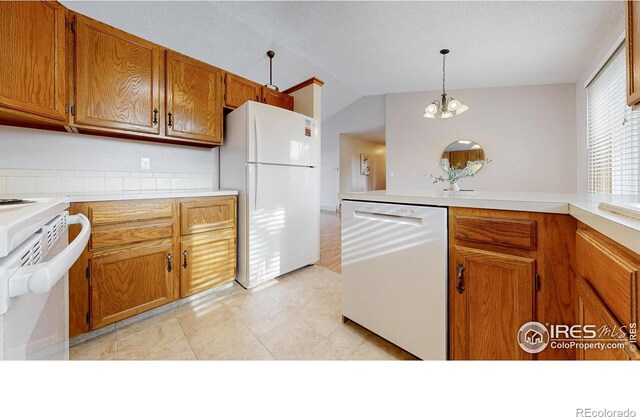 kitchen with light countertops, brown cabinets, vaulted ceiling, and white appliances