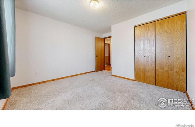 unfurnished bedroom with a closet, carpet, and baseboards