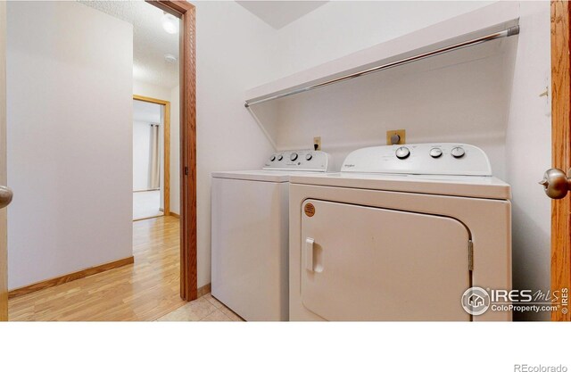 laundry room with light wood-style floors, baseboards, laundry area, and independent washer and dryer