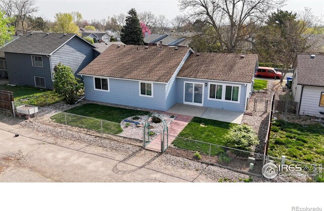 view of front of property featuring a front lawn, a fenced backyard, a gate, a shingled roof, and a patio area