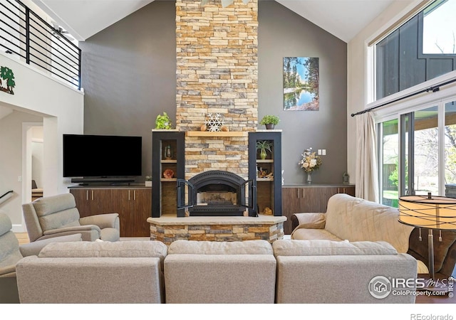 living room featuring plenty of natural light, a fireplace, and high vaulted ceiling