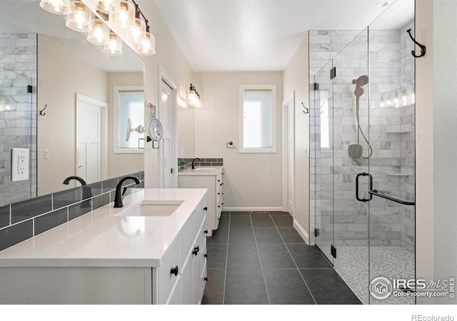 full bathroom featuring vanity, baseboards, a shower stall, and tile patterned floors