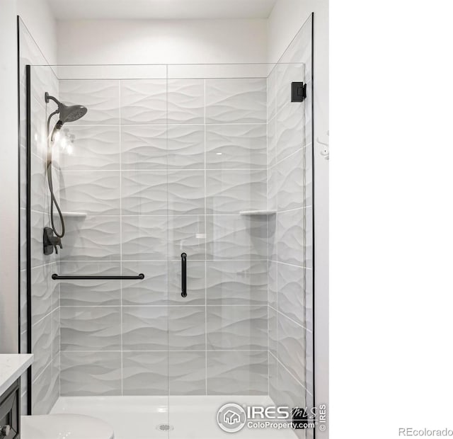 full bathroom with vanity, a stall shower, and toilet