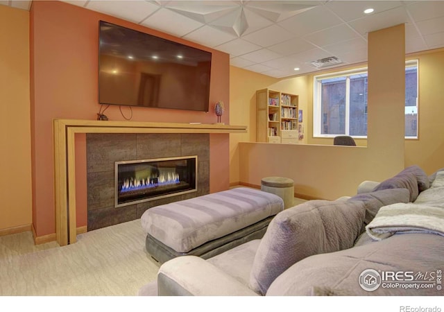 1025 Neon Forest Cir, Longmont, CO 80504 - carpeted living area featuring baseboards, a paneled ceiling, and a tile fireplace