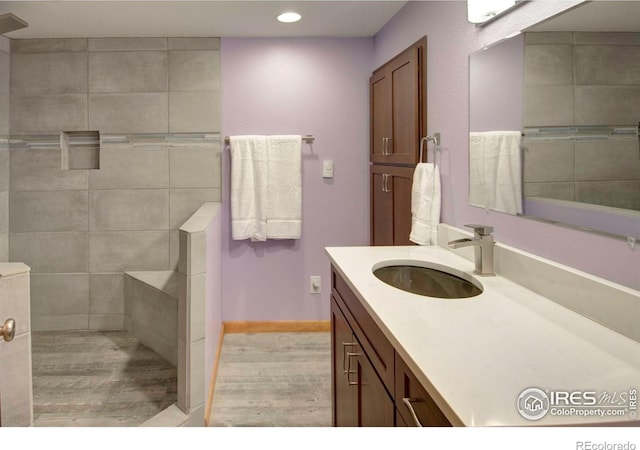 1025 Neon Forest Cir, Longmont, CO 80504 - bathroom with wood finished floors, vanity, walk in shower, recessed lighting, and baseboards